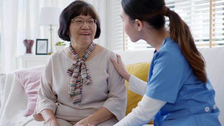 Older adult and family member reviewing care notes in a bright assisted living apartment.